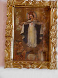 Foto del cuadro de la Virgen del Rosario en madera tallada y policromada con ojos de cascarón de vidrio, corona de plata repujada y cincelada
